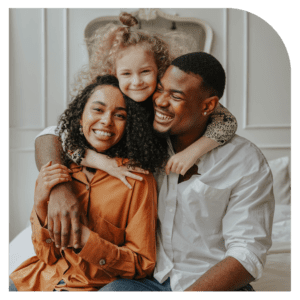 A happy family with an adopted child, embracing in a cozy living room, symbolizing warmth and togetherness.