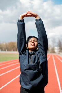 A woman stretching for a run, preparing for physical activity, highlighting the importance of regular exercise in supporting both physical and mental health during surgical recovery.